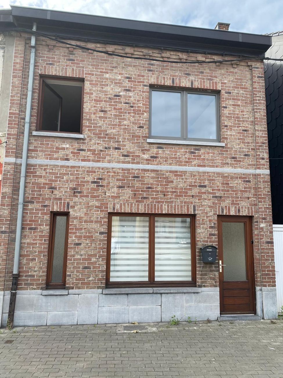 Fenêtres PVC et porte bois sur façade brique